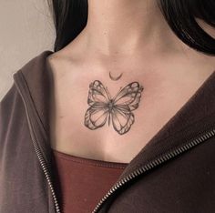 a woman's chest with a butterfly tattoo on her left shoulder and crescent moon behind it