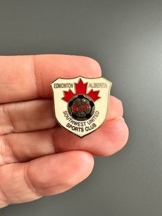 someone is holding a badge in their hand that says edmonton, canada with the canadian maple leaf on it