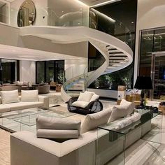 a large living room with white couches and a spiral staircase in the middle of it