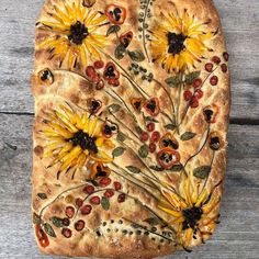 a square shaped pizza with sunflowers and berries on it