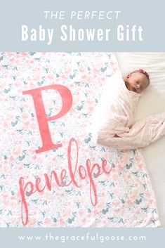 a baby laying on top of a bed next to a blanket with the letter p