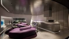 a room with purple couches and tables in it