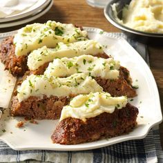 meatloaf with mashed potatoes and herbs on a white plate, ready to be eaten