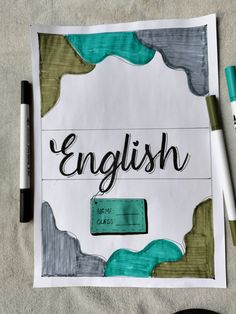 a piece of paper with the word english written on it next to markers and pens