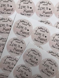 some pink stickers that say love is sweet and have a heart on them with black lettering