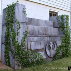 an outdoor bench made out of concrete with ivy growing on the sides and around it