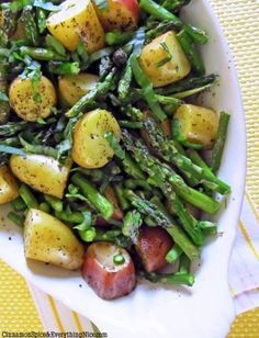 asparagus and potatoes in a white bowl on a yellow tablecloth