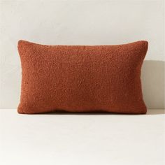 an orange pillow sitting on top of a white table