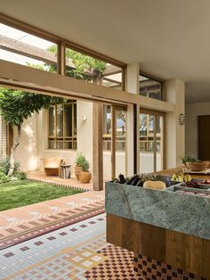 a kitchen area with an outdoor dining table and tiled flooring in front of the house