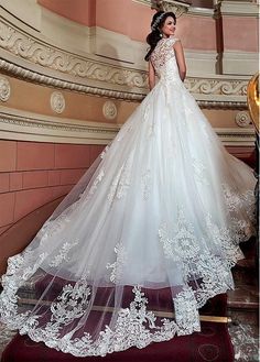 a woman in a wedding dress standing on stairs