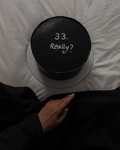 a woman is holding her cell phone in front of a cake that says 3 3 really