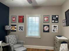 a baby's room with gray walls and pictures on the wall