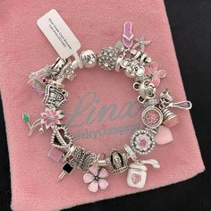 Linx Snake Chain Style Charm Bracelet With A Ball Clasp, Featuring Linx Logo. The Bracelet Comes With 11 Unbranded And 8 Linx Charms In Sterling Silver, With Other Alloy Metals, And 925 Sterling Silver. *The Bracelet Is Available In Multiple Sizes *Additional Charms Can Also Be Added To The Bracelet And The Ones Included Are Removable As Well. *All Of Our Items Are New, Directly From Our Store And Will Be Delivered In A Luxury, Signature Pink, Linx Velvet Jewelry Pouch. *Please Add 1 In To The M Pink Themed Pandora Bracelet, Charms For Bracelet, Pink Charms, Pink Jewelry Aesthetic, Pink And Silver, Bracelet With Charms, Charm Bracelet Ideas, Charm Bracelet Aesthetic, Bracelet Charms