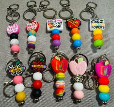 there are many key chains that have different colors and designs on them, including one with an apple