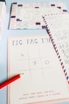 two envelopes and a pencil sitting on top of each other next to some cards