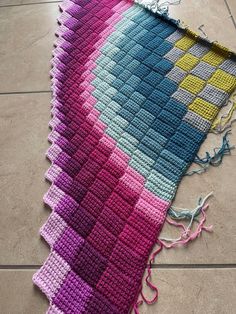 a crocheted blanket laying on the floor