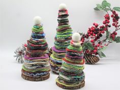 three knitted christmas trees sitting next to each other