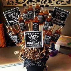 a birthday cake with liquor bottles in it and some signs on the top that say happy birthday