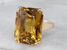 "This is a classic piece from the 1970s! The tab prongs and open-work style setting brings a wonderful sense of light and movement to the bright golden yellow citrine that we've set at the center! This big, bold, and color-filled stone is sure to be a conversation starter! Metal: 14K Yellow Gold Gem: Citrine 22.10 Carats Gem Measurements: 19.5 x 15.3 mm, Cushion Cut Ring Size: 6.50 Marks: \"14K\" Stamped on the inside band SKU #: A1464 Each piece has been identified and graded by a Graduate Gemo Rose Gold Halo Ring, Opal Solitaire Ring, Halo Band, Rose Gold Halo, Floral Engagement Ring, Citrine Jewelry, Pearl And Diamond Ring, Cushion Cut Ring, Sapphire Solitaire