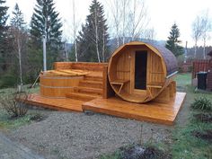 a wooden hot tub sitting on top of a lush green field