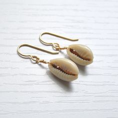 Simple & cute describe these whole cowrie shell earrings! They're the perfect accessory to wear with your favorite casual outfit when you're out & about. Please allow for variations in size and shape of shells as each is unique. Trendy Shell-shaped Jewelry Gift, Casual Shell Jewelry Gift, Handmade Cowrie Shell Earrings For Gift, Handmade Cowrie Shell Earrings As Gift, Summer Gift Shell-shaped Earrings, Cowrie Shell Dangle Jewelry For Gifts, Cowrie Shell Dangle Jewelry Gift, Gold Cowrie Shell Earrings For Gift, Gold Cowrie Shell Earrings As Gift