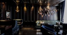 a living room with couches, chairs and chandeliers hanging from the ceiling