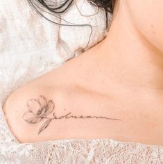 a woman with a flower tattoo on her shoulder and the word faith written in cursive writing