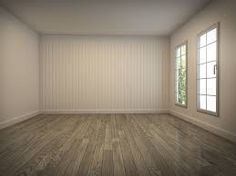 an empty room with wooden floors and white walls, looking out the window at trees