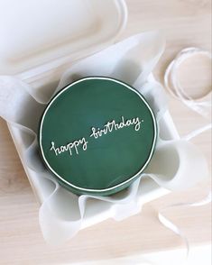 a green birthday cake sitting on top of a white plate with the words happy birthday written on it