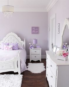 a bedroom with purple walls and white furniture