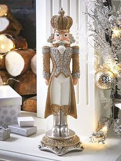 a figurine is sitting on top of a white mantle in front of a christmas tree