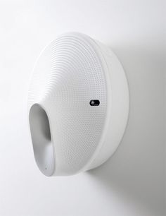 a white speaker mounted to the side of a wall