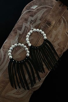 Beautiful handmade boho, hippy, rodeo cowgirl rhinestone statement earrings. Hand knotted and created by me.  These earrings are approximately 4.5 inches in total length. They are very lightweight considering their size. They feature white/clear rhinestones encircling silver hardware. Sleek and trendy circle shape, with rich contrasting black suede leather fringe. Very eye catching on the ear. Country girl glam!  Large and showy. Perfect for rodeo, festival and concert season!  These beauties pa Festival Concho Dangle Jewelry, Adjustable Concho Earrings For Festival, Trendy Festival Jewelry With Fringe, Party Beaded Fringe Earrings Adjustable, Western Style Silver Party Jewelry, Western Silver Jewelry For Parties, Western Style Silver Jewelry For Party, Bohemian Concho Earrings For Festival, Festival Fringe Metal Jewelry