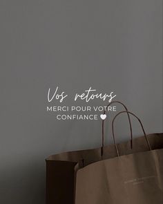 a brown shopping bag sitting on top of a table next to a wall with the words vos retours merci pour votre confiance