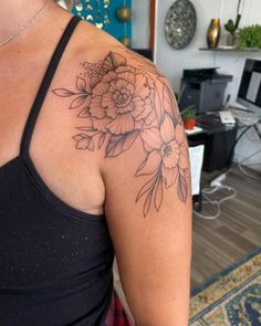 a woman with a flower tattoo on her shoulder