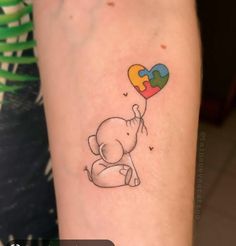 an elephant holding a heart shaped puzzle piece tattoo