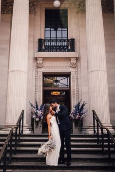 a bride and groom kissing in front of the entrance to their wedding reception at the metropolitan club