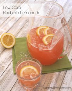 a pitcher and two glasses filled with lemonade sitting on top of a wooden table