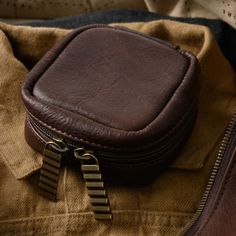 a brown leather case sitting on top of a piece of cloth