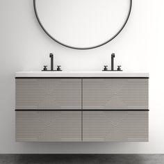 a bathroom vanity with two sinks and a round mirror on the wall above it, in front of a white wall