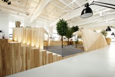 an office with wooden walls and stairs leading up to the second floor, as well as potted trees