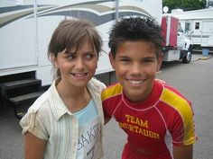 two children standing next to each other in front of a trailer