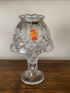 a clear glass vase sitting on top of a wooden table