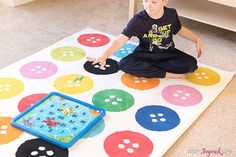 a young boy sitting on the floor playing with a board game