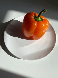 an orange bell pepper on a white plate