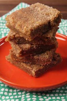 a stack of brownies sitting on top of an orange plate