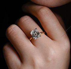 a woman's hand with a ring on it and a diamond in the middle