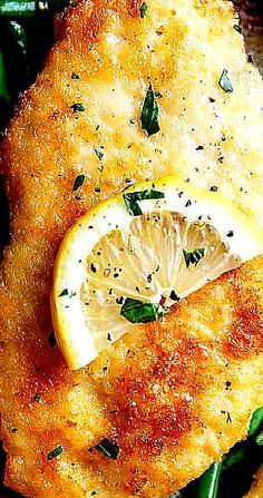 a close up of some food on a plate with lemons and spinach leaves