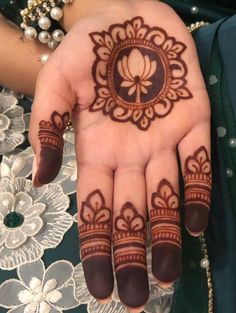 a woman's hand with henna tattoos on it