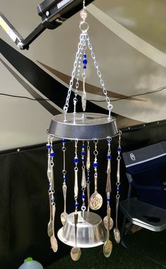 a wind chime hanging from the side of a boat with beads and charms on it